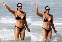 Luiza Brunet vai à praia  e faz gesto obsceno e poses para fotógrafo