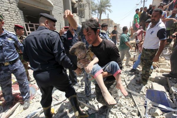 Homem carrega criana achada debaixo de destroos aps casa ser bombardeada por engano em Bagd nesta segunda-feira (6)