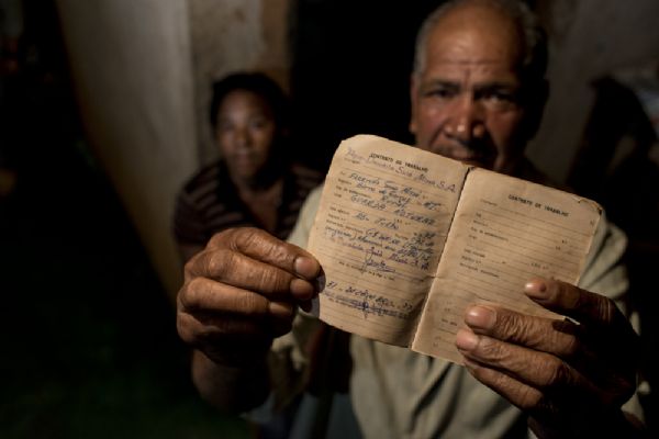 João Guarda, ao lado da esposa, mostra carteira de trabalho com registro da antiga fazenda Suiá Missú