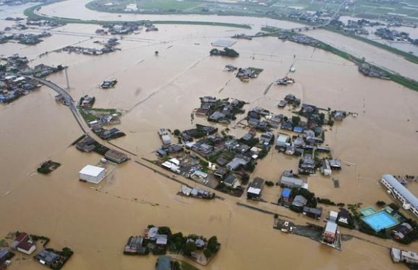 Casas parcialmente submersas após enchente do Rio Yabe, no topo, em Yanagawa, na província de Fukuoka, no Japão, neste sábado (14)