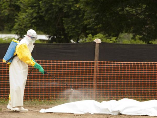 Funcionrios desinfetam corpo de vtima do ebola na Libria: governo tem sido criticado por resposta a surto