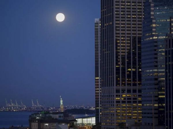 Lua azul, chamada assim por ser a segunda lua cheia do ms,  vista perto da Esttua de Liberdade, em Nova York, nesta sexta-feira (31)