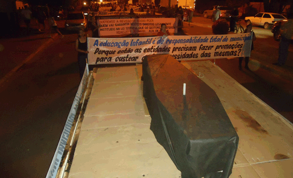 Vestidos de preto, servidores carregam caixo e protestam contra prefeito