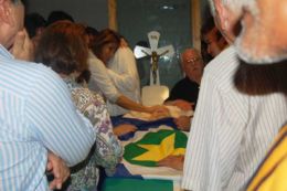 Familiares choram ao lado do cacho de Garcia Neto durante velrio na capela Orqudias