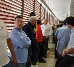 Pivetta conversa com eleitor enquanto aguarda na fila para votar.