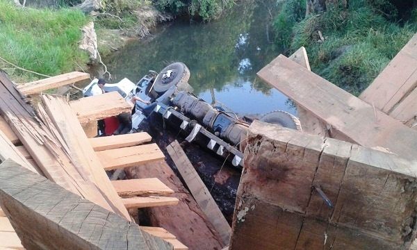 Ponte de madeira cede com peso de caminho e motorista morre ao cair em rio