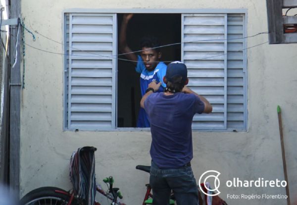 Policial tenta retirar o suspeito, Andr, pela janela da casa onde ele se escondia