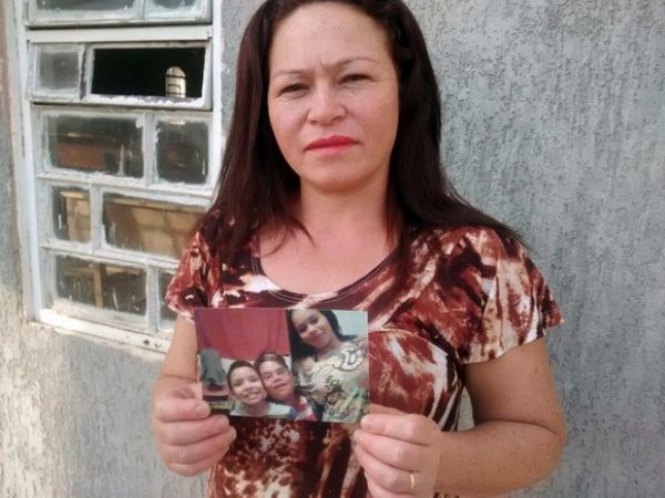 Ex-usuria de drogas que morou em bueiro no Distrito Federal, Odnia Batista Garcez segura fotos dos trs filhos