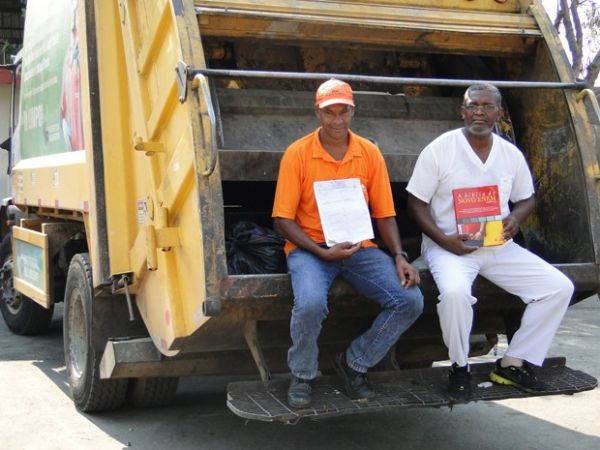 De blusa laranja, Milton Marinho exibe certificado de concluso do Ensino Mdio; de uniforme branco, Domingos Costa carrega livro de preparao para o Enem