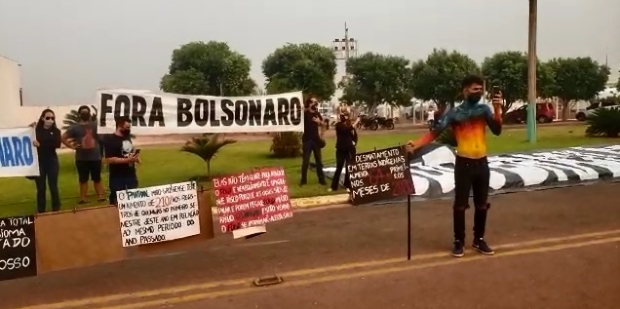 Com caixo e corpo pintado com chamas, manifestantes protestam na chegada de Bolsonaro a MT