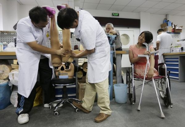 Chinesa que andava com auxlio de bola de basquete consegue prteses